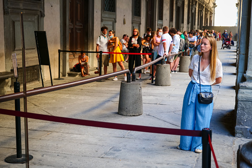 Florence, Italy, August 12 -- Dozens of tourists are waiting in the outdoor patio to visit the Galleria degli Uffizi in Florence, near Piazza della Signoria. The Uffizi Gallery is one of the most important museums in the world, with the Medici's family heritage and some of the major collections of paintings and sculptures by artists such as Leonardo da Vinci, Raphael and Botticelli, as well as numerous works by Giotto, Tiziano, Pontormo, Bronzino, Andrea del Sarto, Caravaggio, Dürer, Rubens, among others. Image in High Definition format.