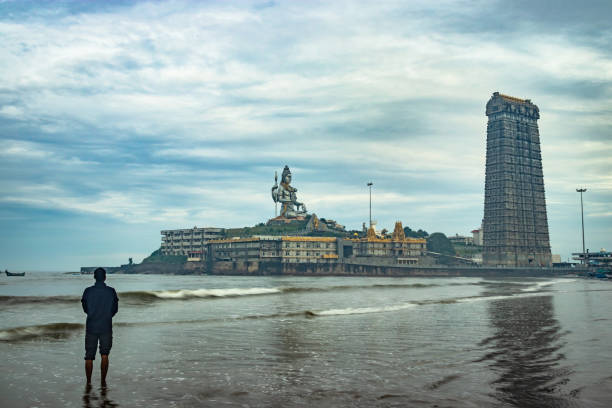 man praying at murdeshwar temple early morning view from low angle image is taken at murudeshwar karnataka india at early morning. it is the house of one of the tallest rajagopuram in the world.