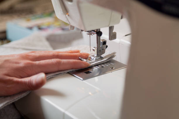istock Seamstress hand guides seam on modern sewing machine 1269006814
