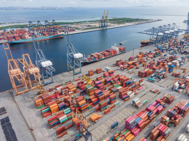 istock Logistics of Container Cargo ship Shot by drone  with working crane bridge in shipyard at sunrise, logistic import export and transport industry background 1269022198
