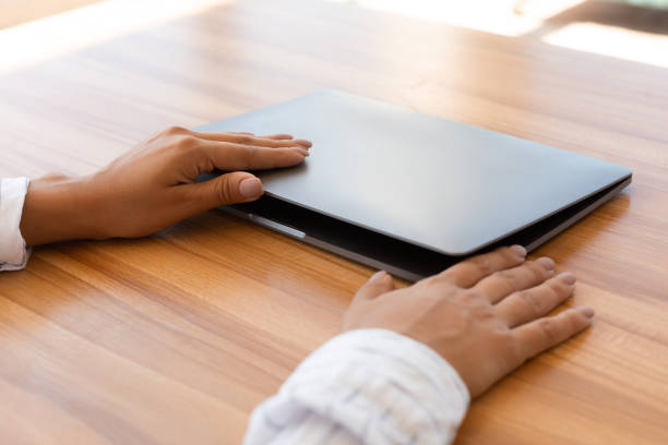 istock Female hand opens laptop on wood table 1269030992