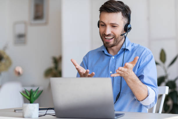 istock Web Conference. Businessman In Headset Having Video Call With Partners Via Laptop 1269031159