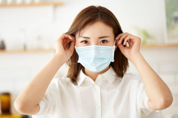 young asian woman putting on a face mask