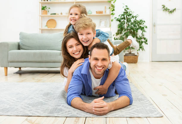istock Parents And Two Children Having Fun Posing Lying On Floor 1269033453