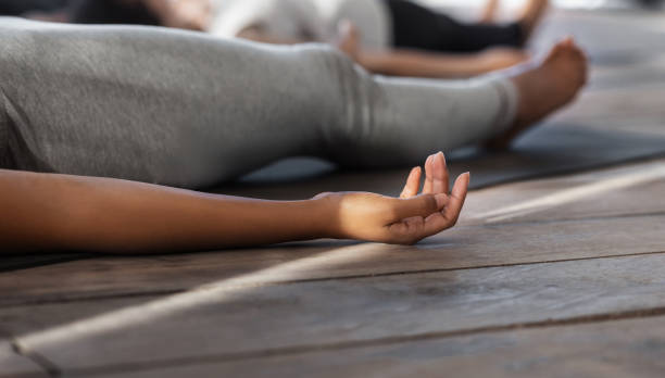 istock Unrecognizable black female practicing yoga in studio, lying in corpse pose, cropped 1269033517