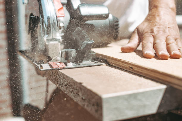 charpentier utilisant la scie circulaire de puissance pour couper le bois, l’amélioration de l’habitat, le faire vous-même (diy) et concept de travaux de construction, coup d’action - work tool carpentry construction wood photos et images de collection