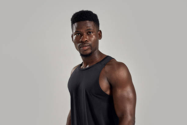 istock Young muscular african american man looking at camera, while posing isolated over grey background. Sports, workout, bodybuilding concept 1269034937