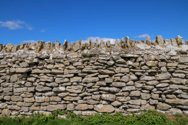 istock An ancient dry stone wall against a clear blue sky. 1269035109
