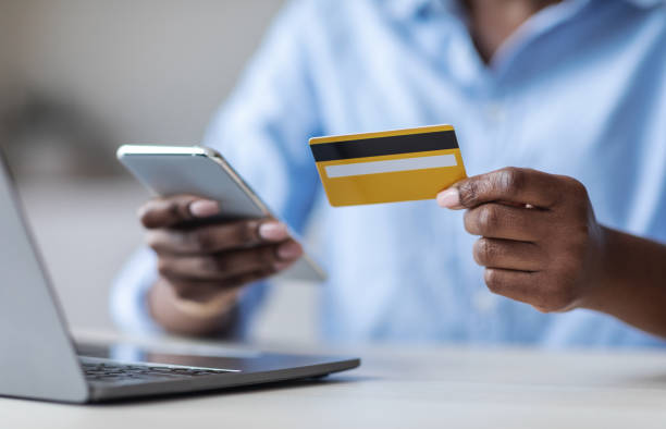 istock Online Payment. Unrecognizable black female using smartphone and credit card in office 1269036612