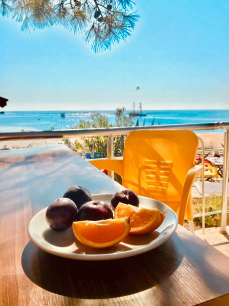 istock Plums and Orange Slices On a Plate at Sea Side 1269037745