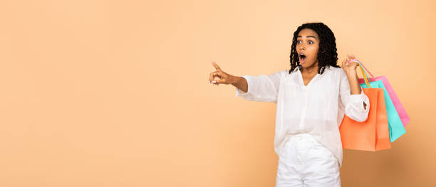 istock Excited Lady With Shopper Bags Pointing Finger Aside In Studio 1269037766