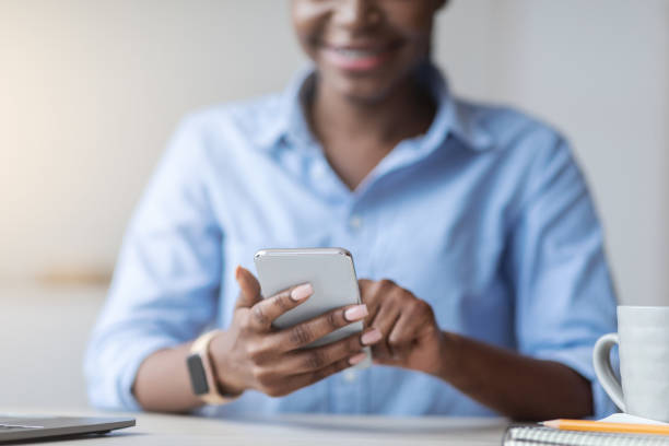 istock Online Payment. Smiling Black Woman Using Smartphone At Workplace In Office, Closeup 1269039436