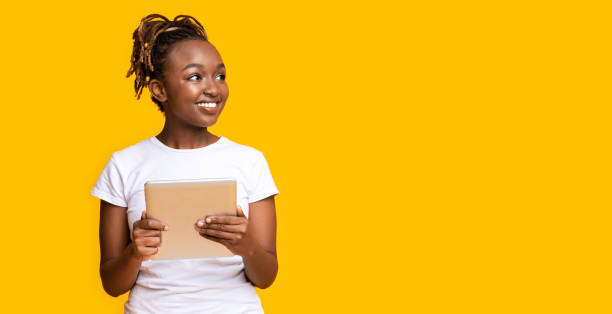 istock Interested black girl with digital tablet looking at free space 1269041490