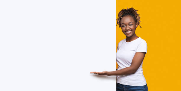 istock Smiling black woman with white empty board for advertisement 1269041864