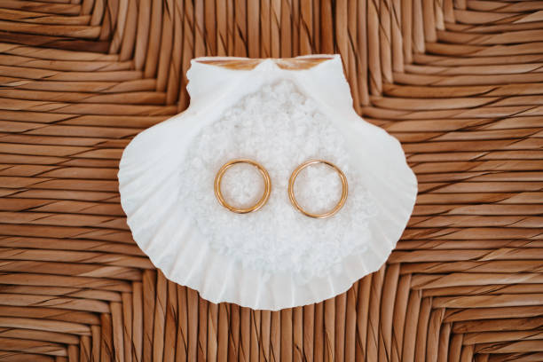 istock Wedding rings in a shell with salt on raffia background 1269042395