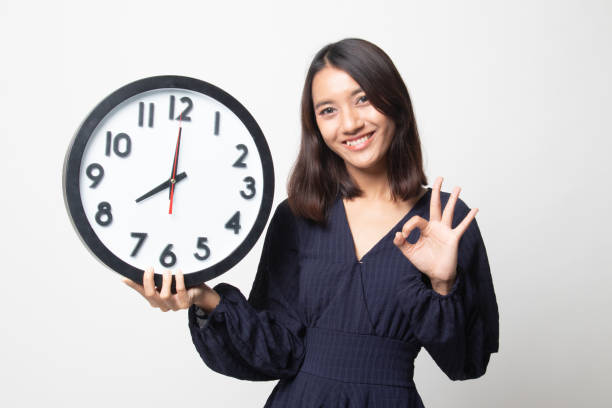 istock Young Asian woman show OK with a clock. 1269045622