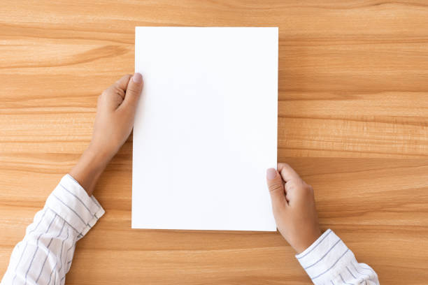 istock Woman hand holding blank paper sheet A4 size 1269045763