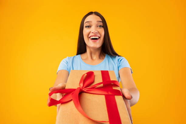 istock Happy lady holding gift box at studio 1269045788