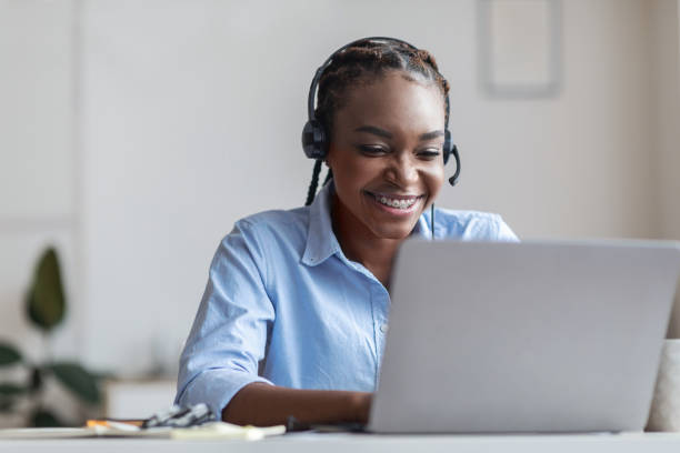 istock Hotline Support Service. Smiling african woman in headset working in modern office 1269047894