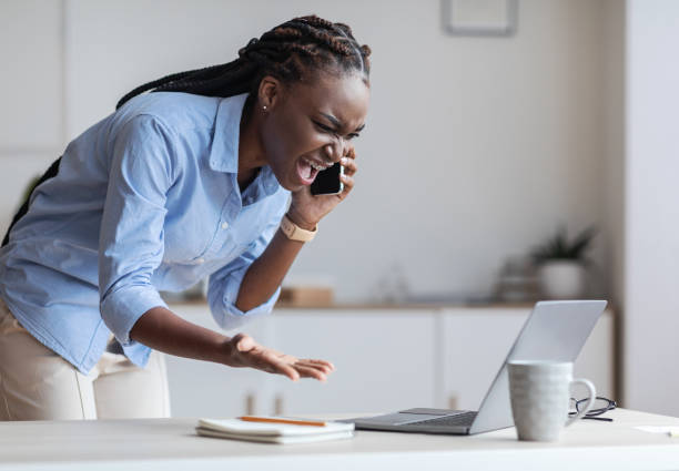 istock Problems At Work. Stressed Black Businesswoman Talking On Cellphone And Screaming 1269048033