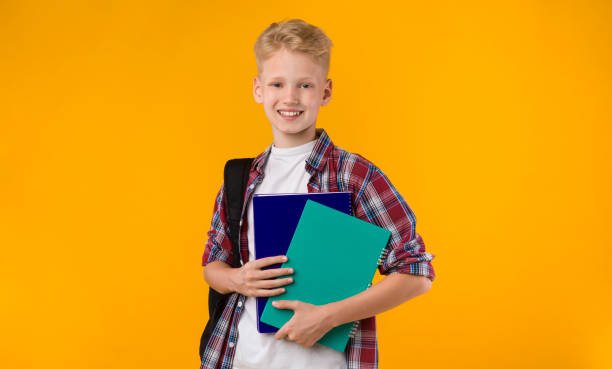 istock Smiling teen posing with textbooks at studio 1269050265