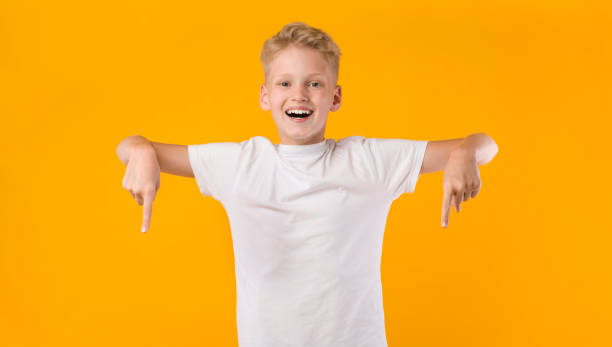 istock Happy boy pointing fingers down at copy space 1269050456