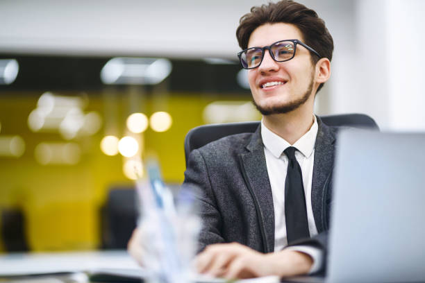 junge büroleiterin arbeitet mit papieren und computerarbeit im büro. - lawyer young adult suit expressing positivity stock-fotos und bilder