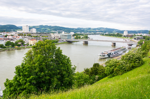 Linz, Austria - May 25, 2017. View over Danube River in Linz, with boats, vegetation and buildings.