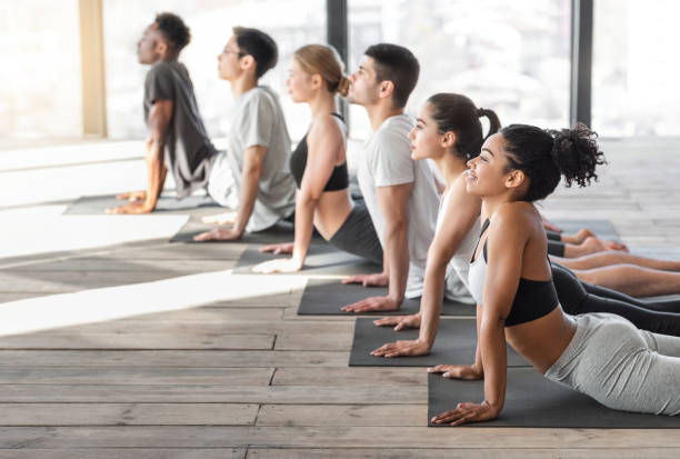 istock Cobra Pose. Young man and woman doing yoga exercises in studio together 1269058332