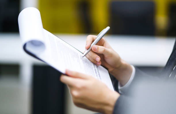 A man signs a contrac, legal or business agreements. A man signs a contrac, legal or business agreements. Male hand with pen of young office worker makes notes. Business man sitting at office desk and signing a document in modern office. witness signature stock pictures, royalty-free photos & images
