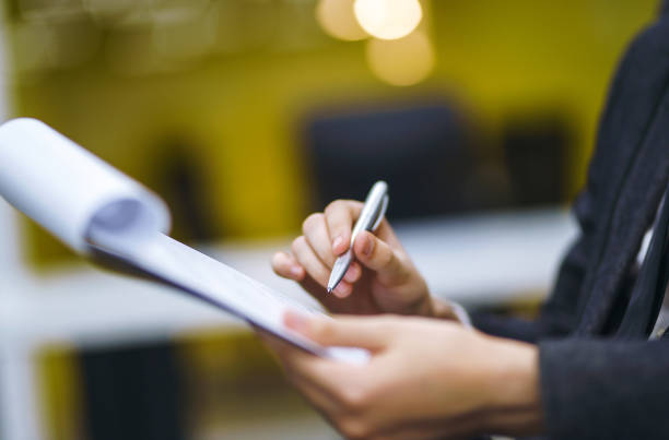 A man signs a contrac, legal or business agreements. A man signs a contrac, legal or business agreements. Male hand with pen of young office worker makes notes. Business man sitting at office desk and signing a document in modern office. witness signature stock pictures, royalty-free photos & images