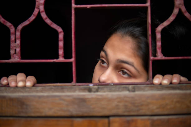 istock sad young girl looking out through the window and thinking. 1269062819