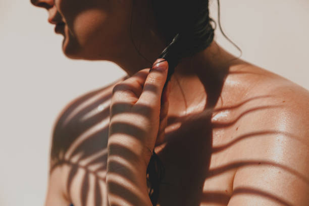istock Shadow from palm tree falls on  girl naked body 1269064027