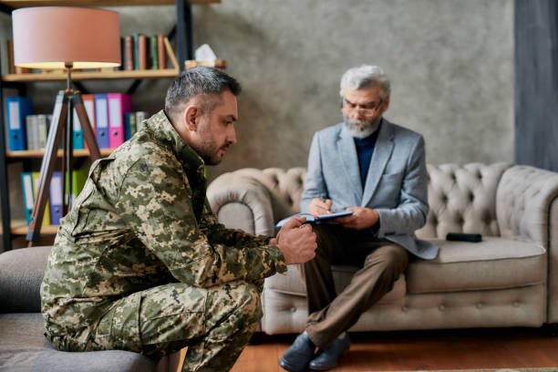 istock Healing. Thoughtful middle aged military man looking away during therapy session with psychologist. Soldier suffering from depression, psychological trauma. PTSD concept 1269064209