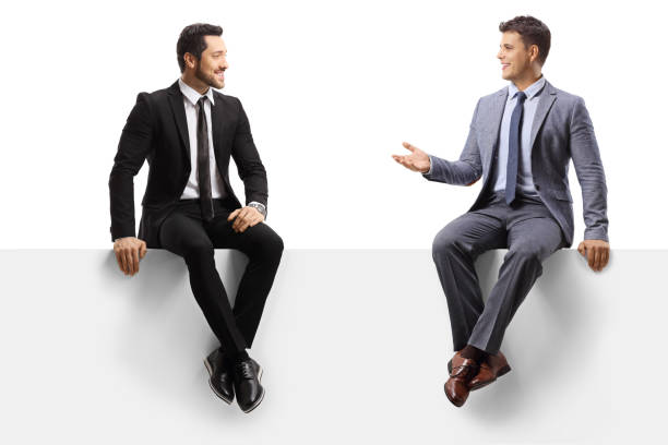 istock Male colleagues sitting on a blank panel and having a conversation 1269067523