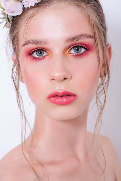 Extra close up portrait of a beauty young girl with nude fashion bright make-up Extra close up portrait of a beauty young girl with nude fashion bright make-up, a hairstyle on head, a hoop made of fresh flowers: peons, field flowers, eucalyptus, ranunculus. Clean skin. Bridesmaid hoops wedding stock pictures, royalty-free photos & images