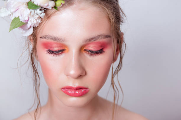 Extra close up portrait of a beauty young girl with nude fashion bright make-up Extra close up portrait of a beauty young girl with nude fashion bright make-up, a hairstyle on head, a hoop made of fresh flowers: peons, field flowers, eucalyptus, ranunculus. Clean skin. Bridesmaid hoops wedding stock pictures, royalty-free photos & images