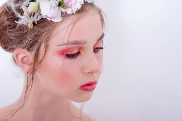 Extra close up portrait of a beauty young girl with nude fashion bright make-up Extra close up portrait of a beauty young girl with nude fashion bright make-up, a hairstyle on head, a hoop made of fresh flowers: peons, field flowers, eucalyptus, ranunculus. Clean skin. Bridesmaid hoops wedding stock pictures, royalty-free photos & images