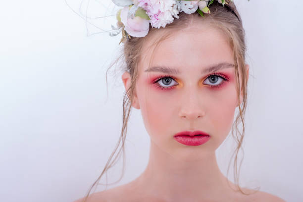 Extra close up portrait of a beauty young girl with nude fashion bright make-up Extra close up portrait of a beauty young girl with nude fashion bright make-up, a hairstyle on head, a hoop made of fresh flowers: peons, field flowers, eucalyptus, ranunculus. Clean skin. Bridesmaid hoops wedding stock pictures, royalty-free photos & images