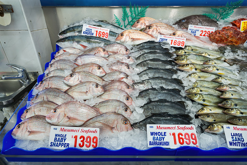Hong Kong SAR, China - August 2, 2013: A fishmonger selling a variety of seafood at a local wet market stall in Taipo, Hong Kong.