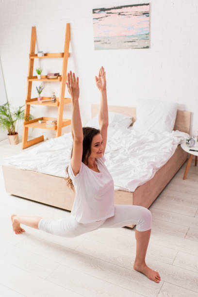 istock young barefoot woman with hands above head standing in warrior pose 1269077970