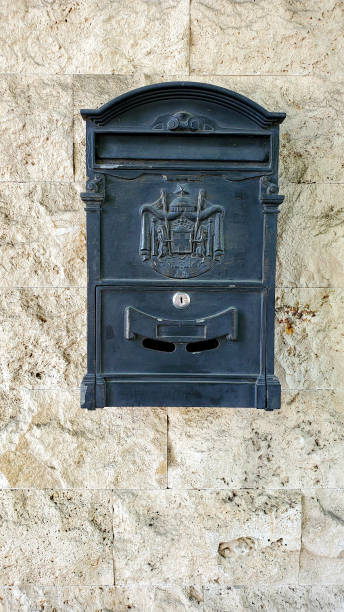 istock Vintage mailbox with antique embossed emblem closeup on rough stone wall background with copy space 1269078113