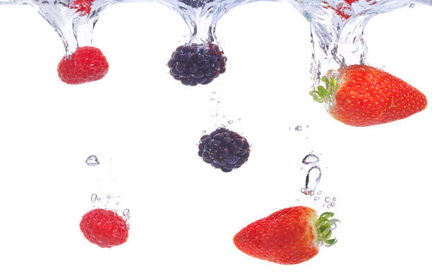 Fruits plunging into water. Strawberry, blackberry and raspberry splashing into fresh water.