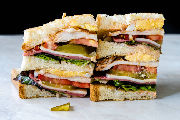 istock Classic Club Sandwich on Marble Surface. Includes Ham, Cheese, Lettuce, Tomato Slices. Light background. Close-up. 1269085859