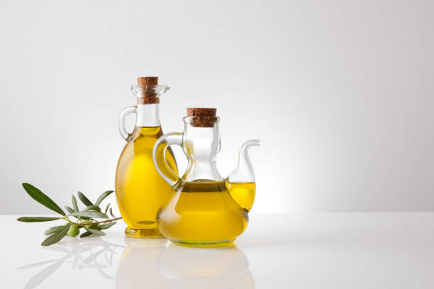 istock Containers with oil and olive twig on white table front 1269098569