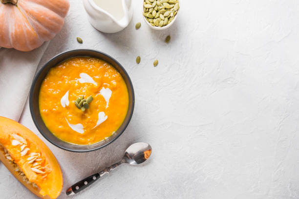 istock Pumpkin soup with cream on grey stone background. Copy space. Top view. 1269098683