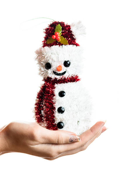 istock Hand holding Christmas snowman figurine isolated on white background 1269102063