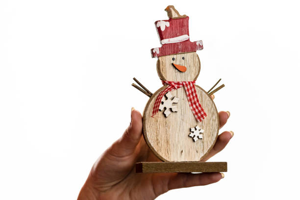 istock Hand holding Christmas snowman figurine isolated on white background 1269102079