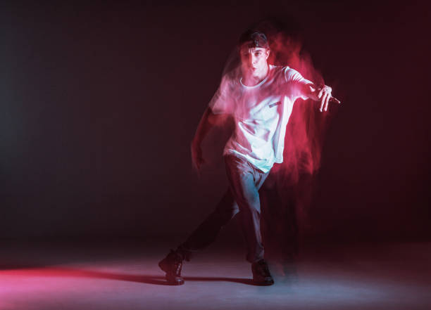 istock Stylish young guy breakdancer dancing hip-hop in neon light. Dance school poster. Long exposure shot 1269107806