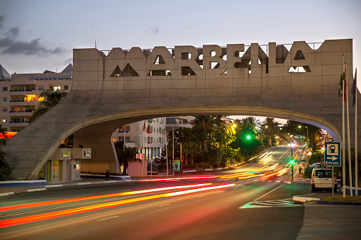Beautiful and emblematic Marbella sign. This iconic entrance sign welcomes visitors to Marbella. Twilight, sunset , long exposure , car lights